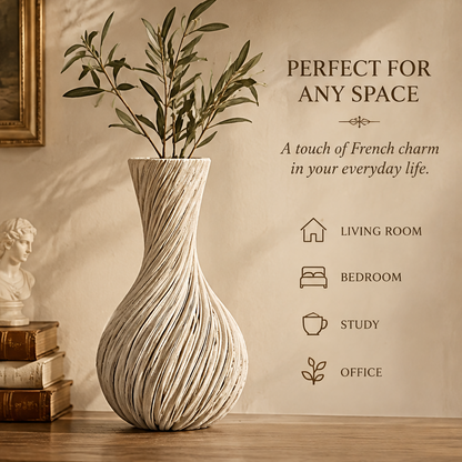 Cream spiral teardrop vase with leafy branches displayed beside books and a classical bust